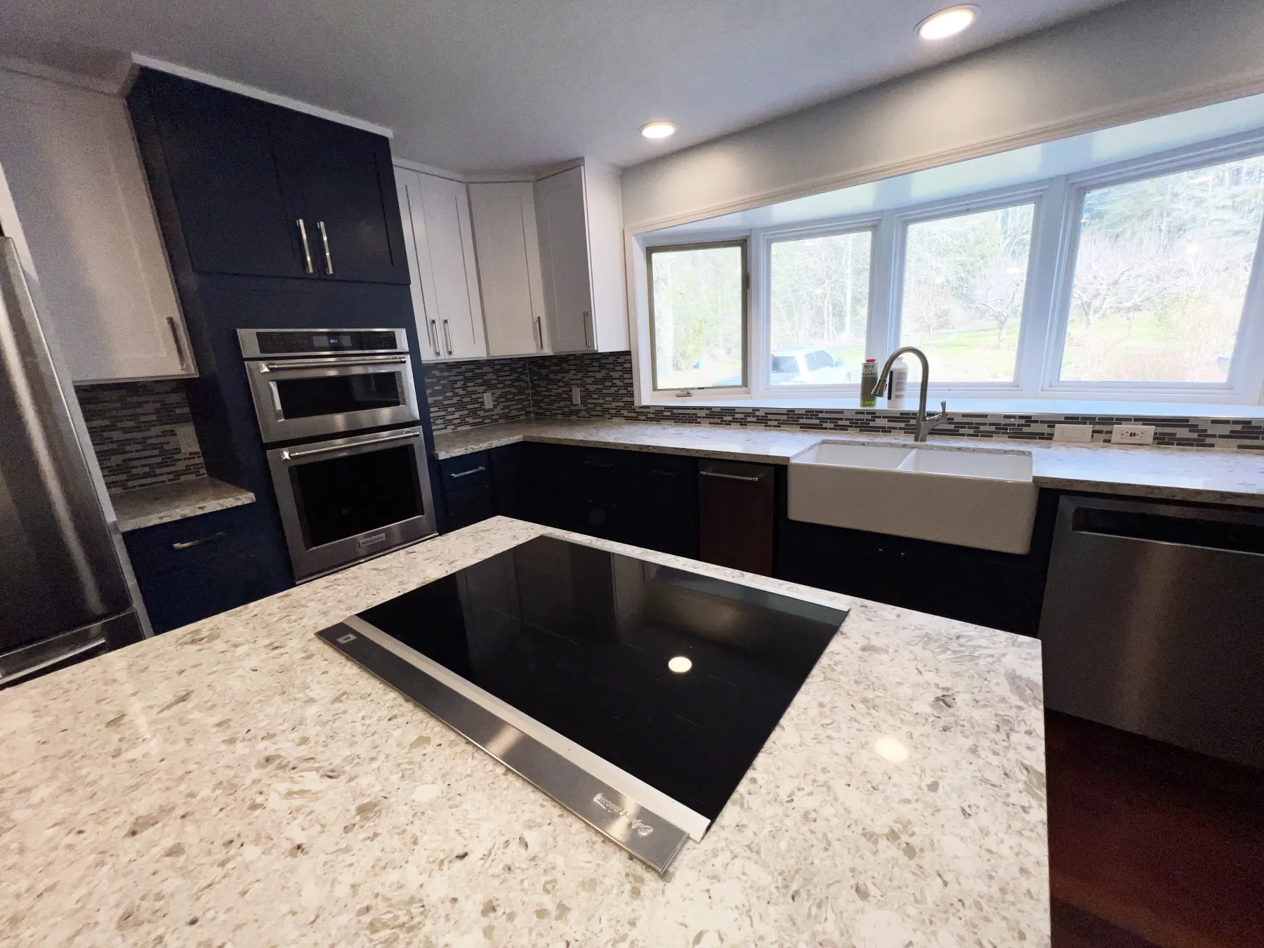Kitchen renovation featuring cabinets, countertops and updated lighting